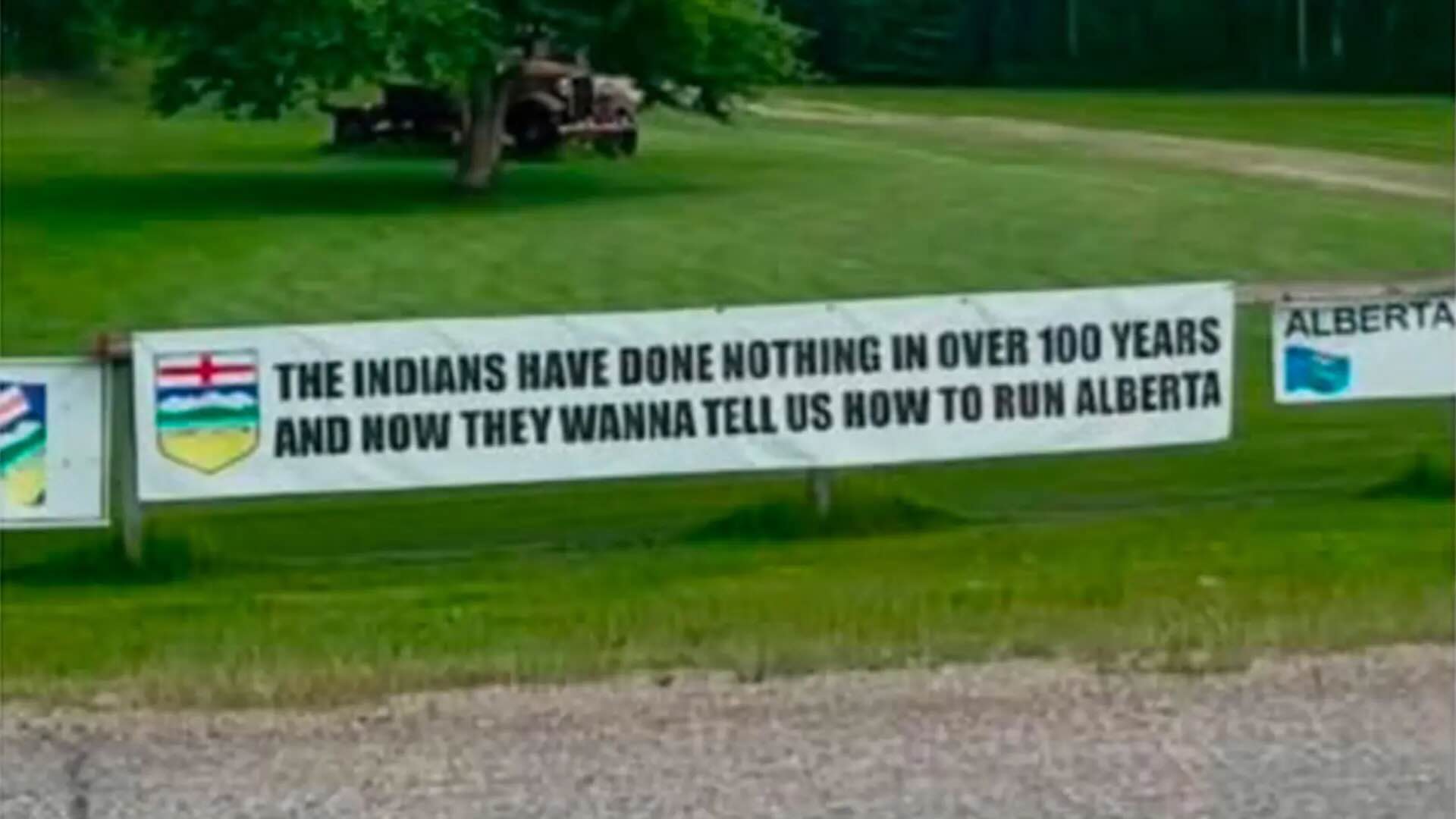 A banner hung on a fence near Spruce Grove, Alberta is drawing criticism from First Nations. Photo: Kara Burnstick/Facebook